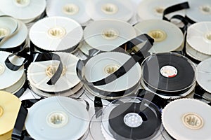 Stack of supply and take up reels with ribbon of VHS video cassette tapes used on old video players and recorders, retro style