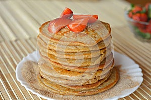 Stack of sweet pancakes with strawberries and cinnamon sugar
