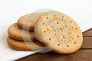 Stack of sweetmeal digestive biscuits on dark wood and napkin. photo