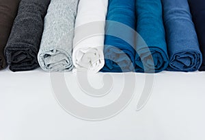 Stack of t-shirt rolled up on white background