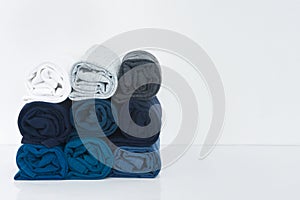 Stack of t-shirt rolled up on white background