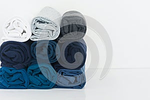 Stack of t-shirt rolled up on white background