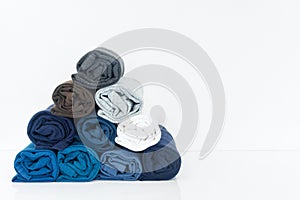 Stack of t-shirt rolled up on white background