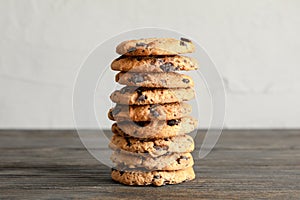 Stack of tasty chocolate chip cookies on wooden table