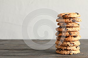 Stack of tasty chocolate chip cookies on wooden table