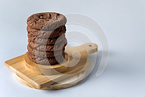 Stack of Tasty Chocolate Cookies on Wooden Cutting Board Blue Background Horizontal Copy Space