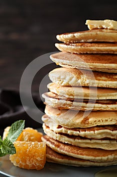 Stack of tasty homemade pancakes and honey comb on plate