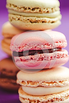 Stack of tasty macarons including vanilla, chocolate and strawberry flavours.