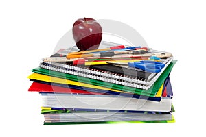 Stack of textbooks with school supplies on top photo