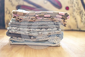 Stack of textile sheets blankets on a wooden shelf f