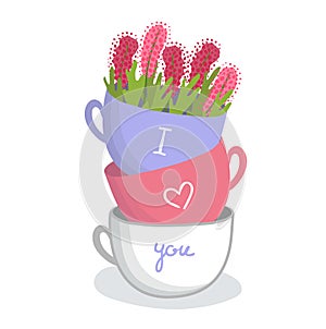 Stack of three colorful teacups with the phrase I love you, flowers in the top cup. Romance, affectionate message, tea