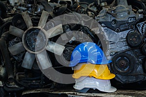 Stack of three colorful worker helmets at workplace manufacturing plant factory construction site building with many engine parts