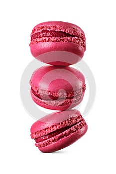 A stack of three vivid red macarons levitated in mid-air isolated on a white. Sweet French sandwich cookies