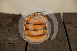 A stack of tied cookies with a rope lies on an wooden table