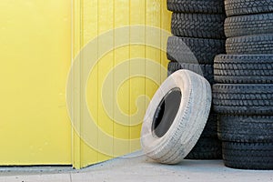 Stack of tires against yellow wall
