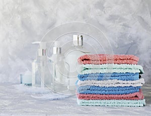 Stack of towels for bathroom bottles on a white marble background, space for text, selective focus