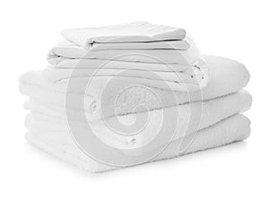 Stack of towels and bed sheets on white background photo
