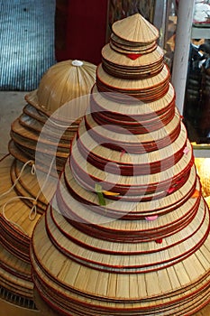 Stack of traditional palm leaf conical hats at a shop in Hanoi, Vietnam