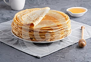 Stack of traditional russian pancakes blini on gray background with copy space.