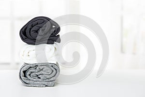 A stack of twisted T-shirts on a white table