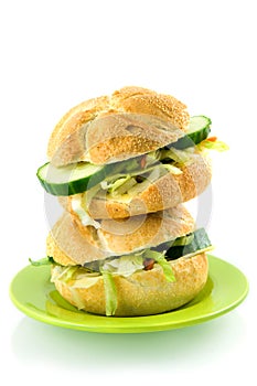 Stack of two fresh sandwiches on a green plate