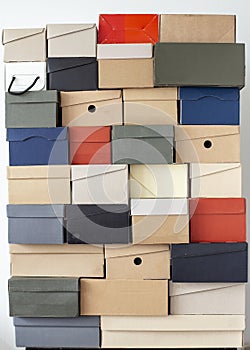 Stack of unevenly folded shoe boxes against a white wall. Seasonal sales and discounts