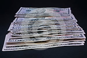 Stack of US 50 dollar bills on black background