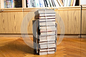 Stack of used books tied with packthread on floor