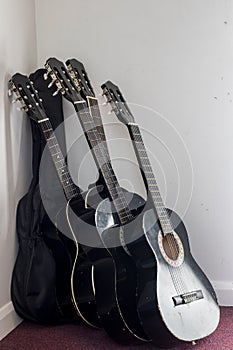 Stack of used classical acoustic guitars in storage