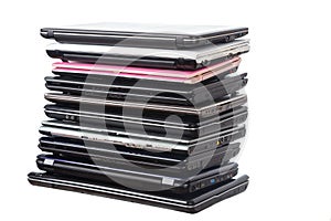 Stack of used laptops in different colors and models. T