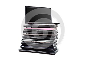 Stack of used laptops in different colors and models. T