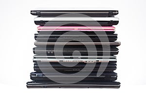 Stack of used laptops in different colors and models. T photo