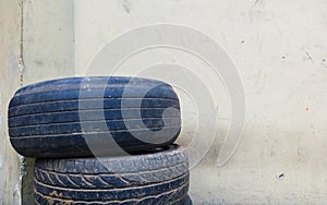 Stack of used secondhand tires on the corner of garage