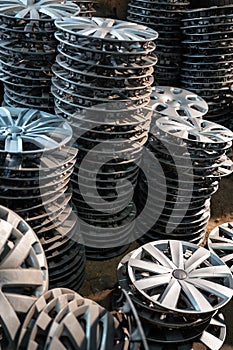 stack of various alloy wheels in tire store