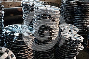 stack of various alloy wheels in tire store