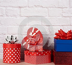 Stack of various boxes with gifts on white brick background