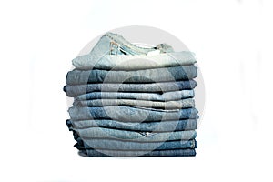 Stack of various shades blue jeans. Jeans stacked isolated on white background. Blue denim jeans texture banner with copy space photo