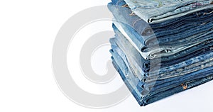 Stack of various shades blue jeans. Jeans stacked isolated on white background. Blue denim jeans texture banner with copy space
