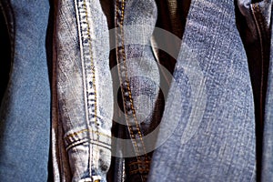 stack of various shades of blue jeans as background