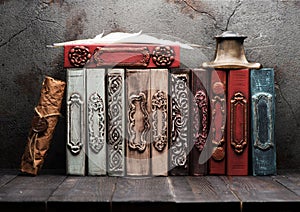 Stack vintage books on a wooden shelf,.inkwell and feather.