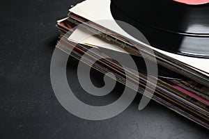 Stack of vintage vinyl records on black background, closeup. Space for text