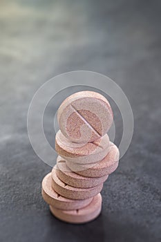 Stack of vitamin mineral supplement effervescent tablets on slate background photo