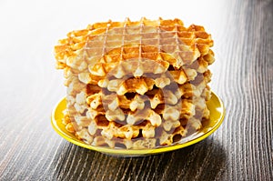 Stack of wafer in saucer on wooden table