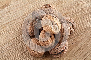 A stack of walnuts piled together and on rustic wooden background, shallow depth of field, selective focus