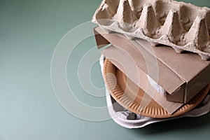 Stack of waste paper on grey table, closeup. Space for text