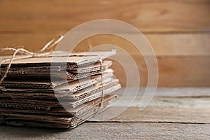 Stack of waste paper on wooden table, closeup. Space for text