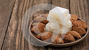 Stack of White Cubes on Plate, Surrounded by Fiberous Pods, Rustic, Wooden Background.