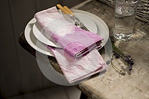 Stack of White Dinner Plates and Purple Cloth Napkins