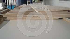 A stack of white MDF panels lies on the floor. Material for the production of furniture, panels. Veneered chipboard in a