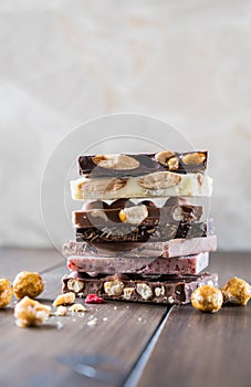 Stack of white, milk and dark chocolate on the wooden table